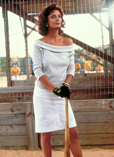 A woman in white dress holding a baseball bat.