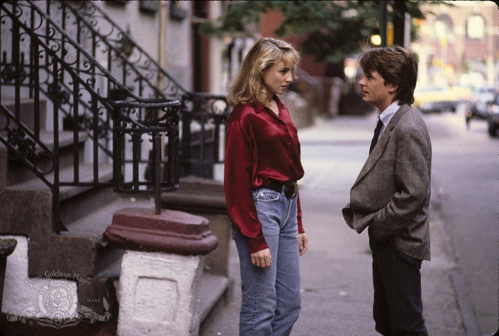 A man and woman standing on the sidewalk.