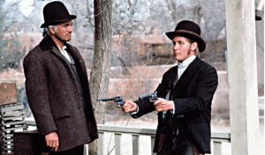 Two men in suits and hats holding guns.