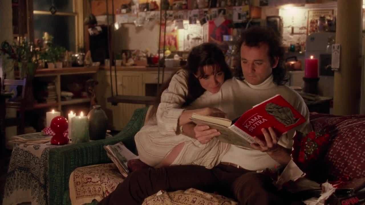 A man and woman sitting on the floor reading.