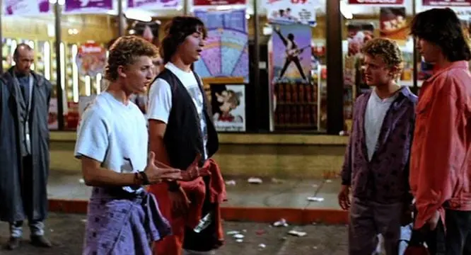 A group of young men standing on the sidewalk.