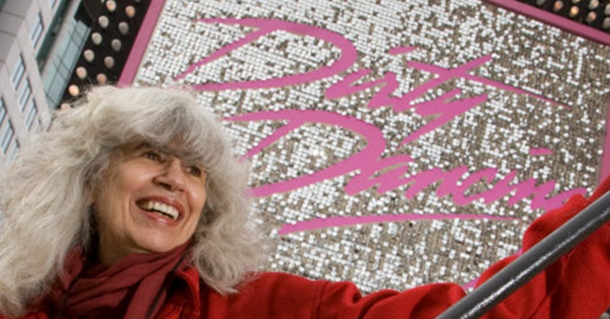 A woman in red jacket standing next to pink and white mosaic.