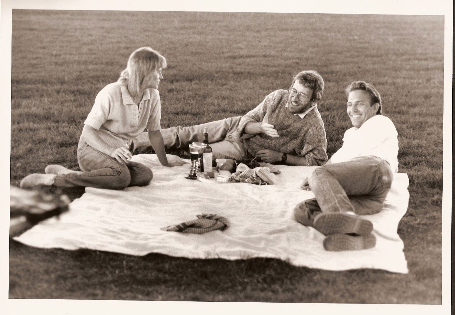 A group of people sitting on top of a blanket.