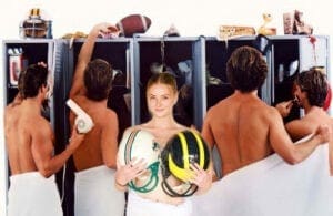 A woman in a towel holding a football helmet.