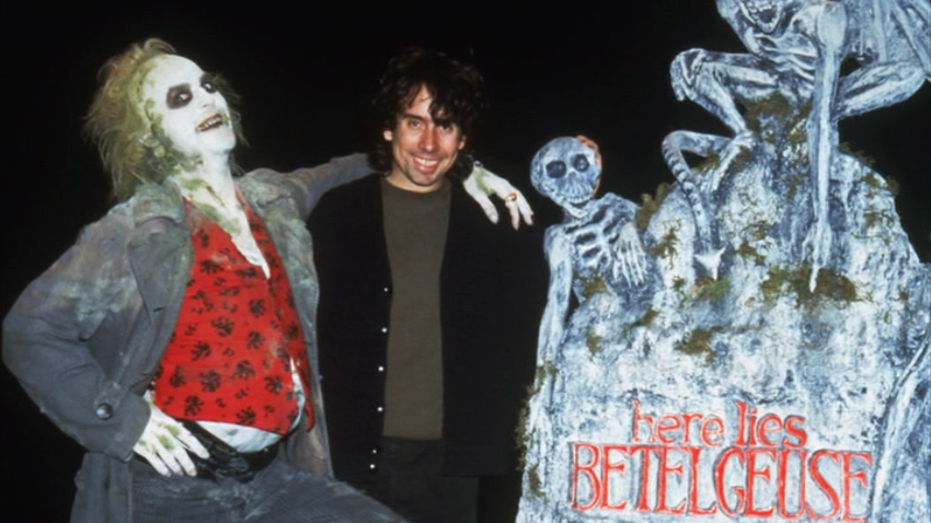 A man standing next to some skeletons and a woman.