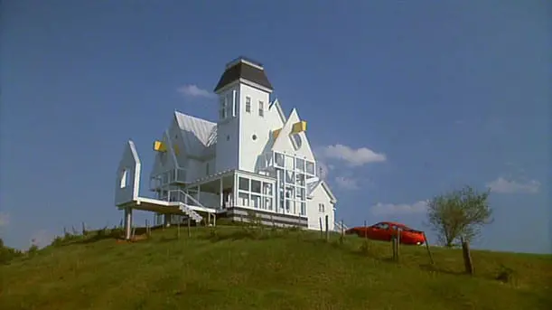 A large white house sitting on top of a hill.