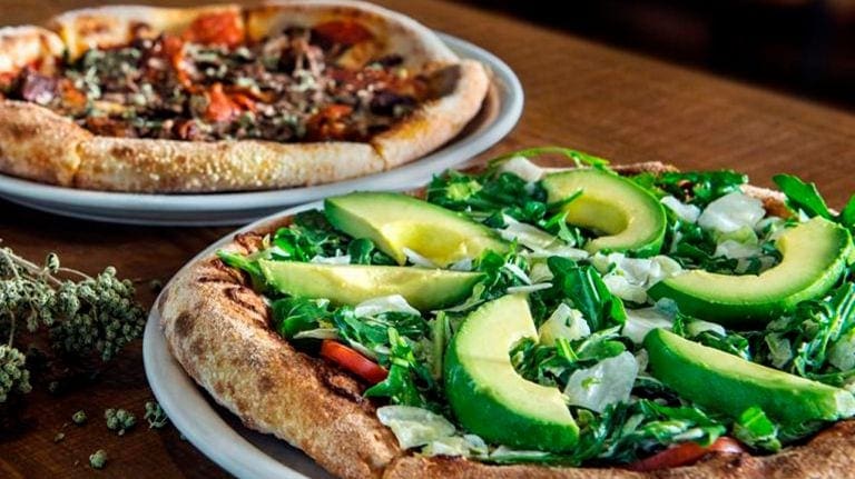 A pizza sitting on top of a pan covered in toppings.