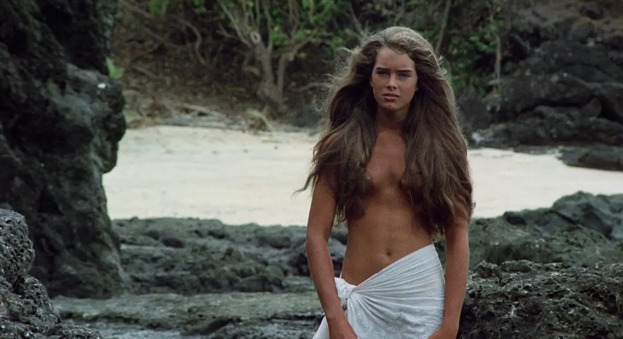A woman with long hair standing on the beach.