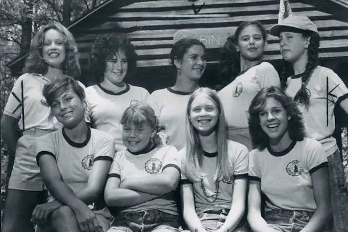A group of girls in matching shirts posing for the camera.