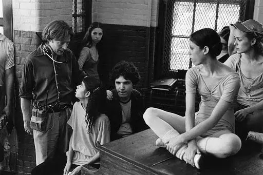 A group of people sitting on top of a wooden table.