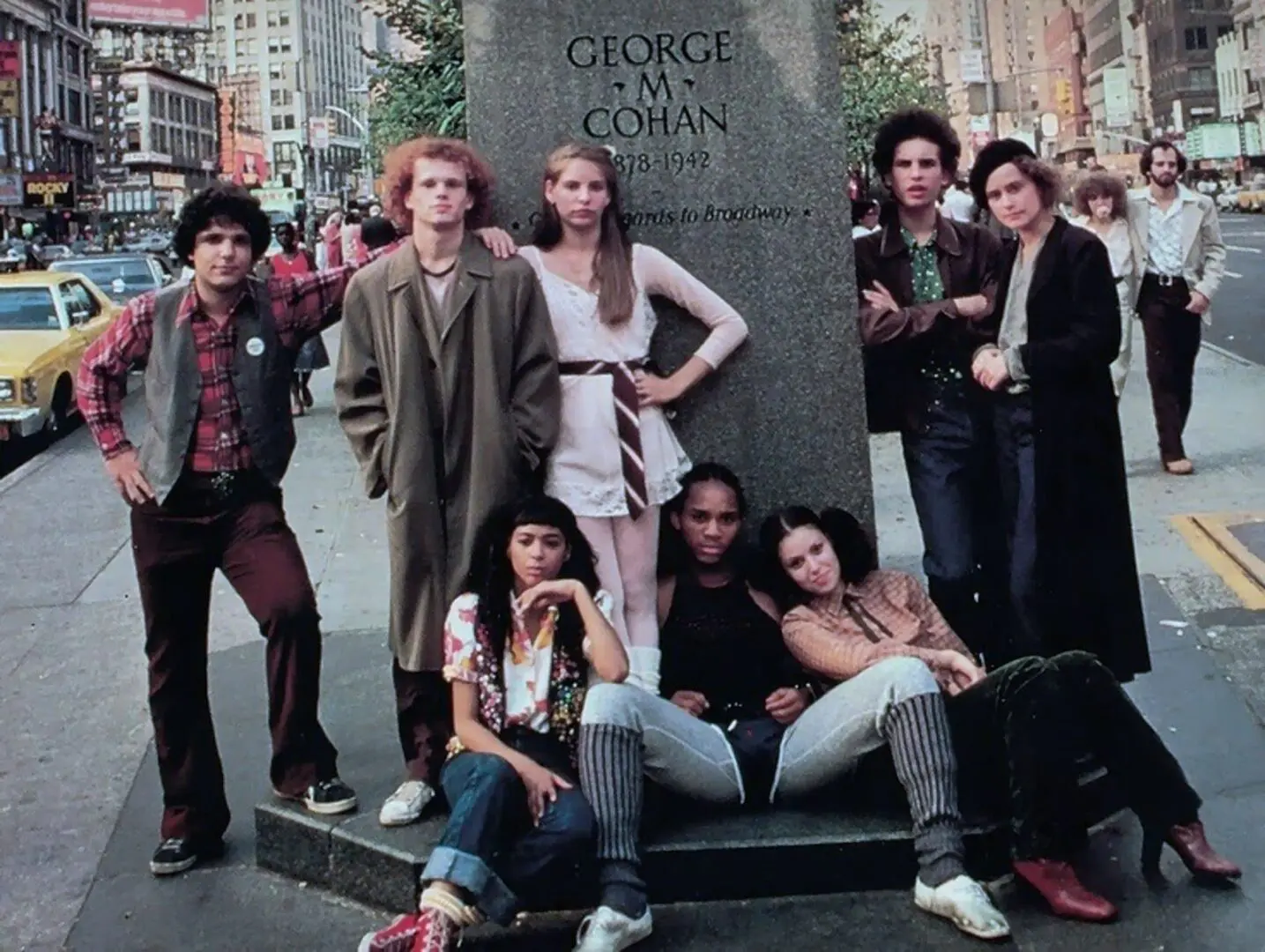 A group of people standing around a statue.