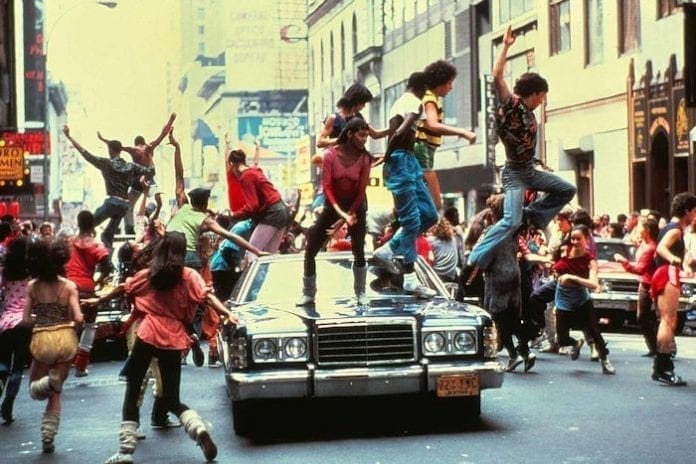 A group of people jumping on top of a car.