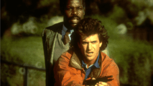 A man holding a gun in front of another man.