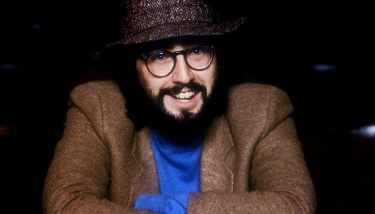 A man with beard and glasses wearing a hat.
